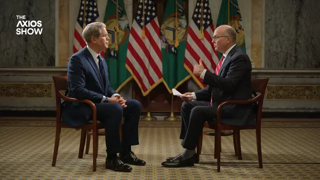 Scott Bessent and Mike Allen on an interview for "The Axios Show" with American flags in the backdrop